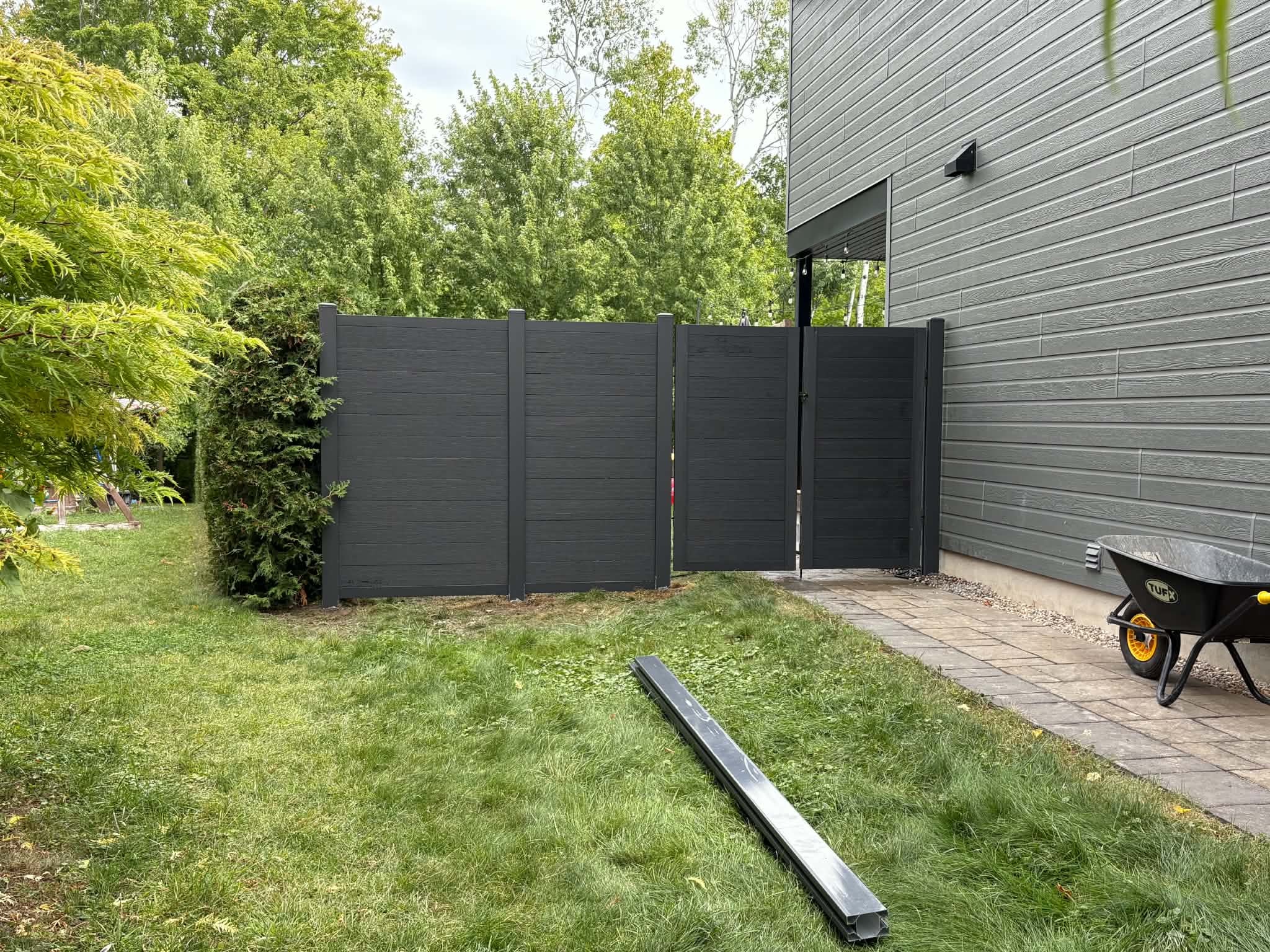 Cloture composite noire avec porte double en cours d'installation