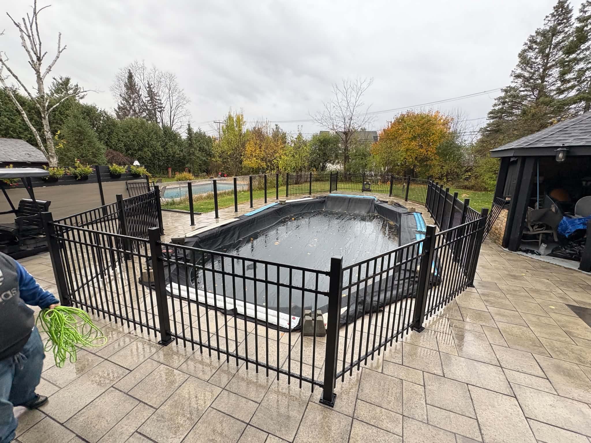Cloture aluminium noire autour d'une piscine creusee vue d'ensemble